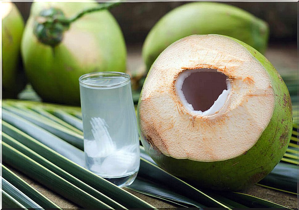 Glass of green coconut water with lemon.