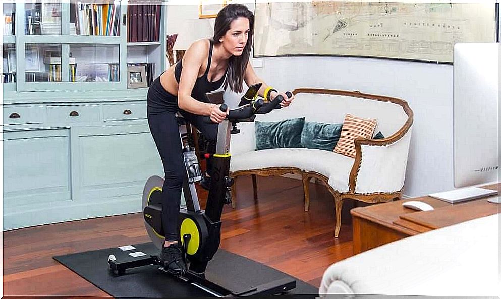 Woman doing exercise bike at home.