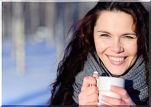 Woman taking an infusion to combat the cold in her hands