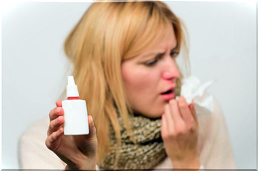 Woman with a cold and a nasal spray