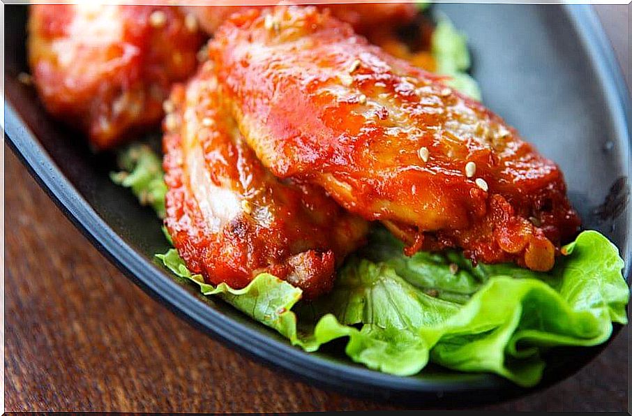 Chicken wings with sauce and lettuce.