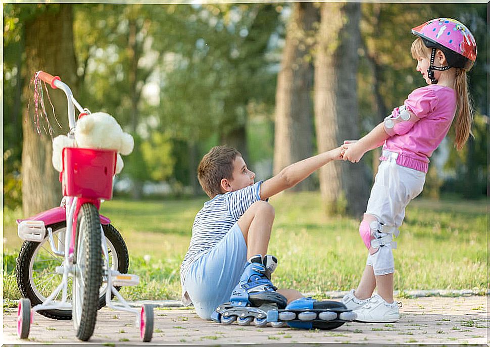 Girl helping a boy to get up.